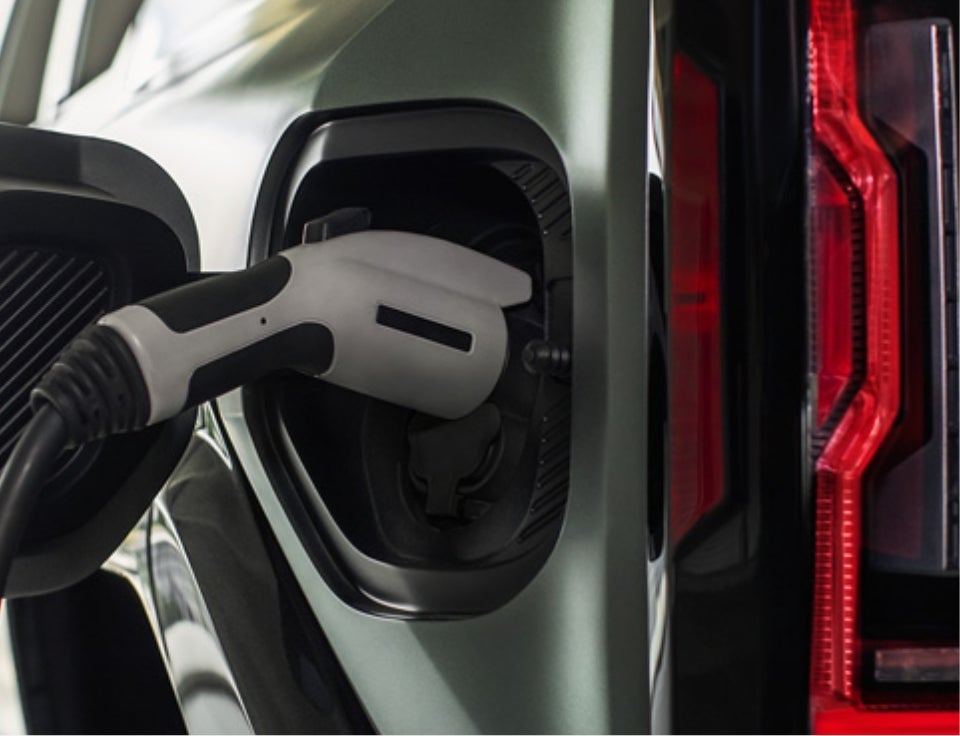 Close up of charging port with charger plugged in on a GMC Hummer EV SUV - Dahl Motors GMC in Pipestone MN