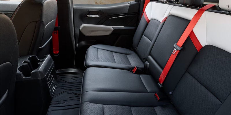 2026 GMC Canyon rear passenger seating with black leather interior and red seat belts