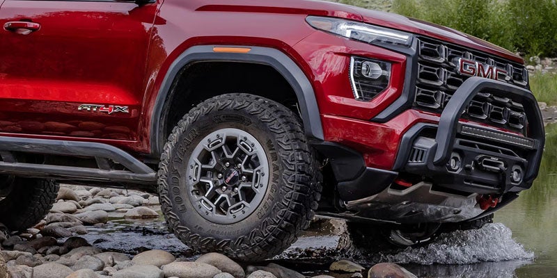 2026 GMC Canyon AT4X red off-road pickup truck on rocky terrain
