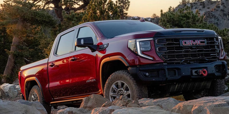 2026 GMC Sierra 1500 red truck off-road driving rocky terrain